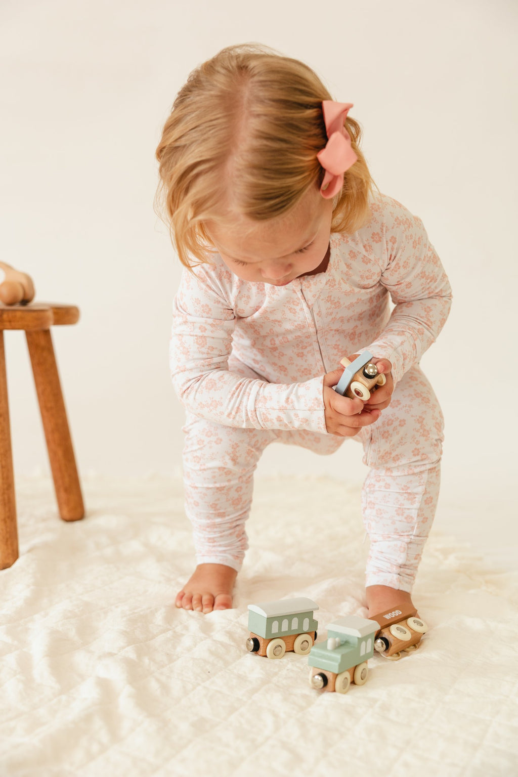 Toddler playing with a toy train in the Blush Blossoms sleeper