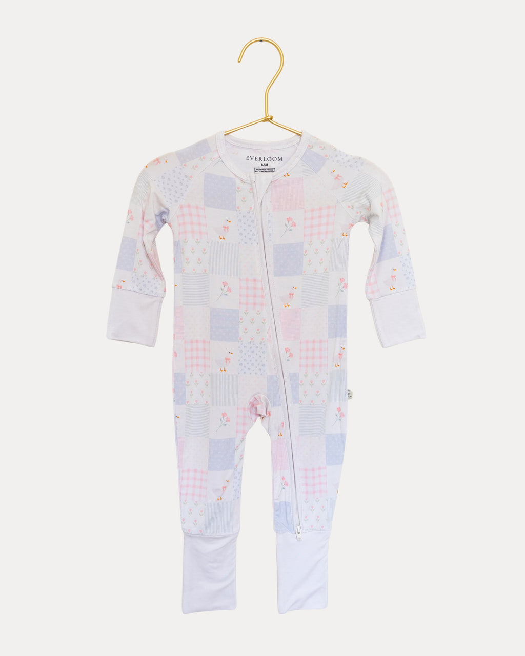 Heirloom Quilt bamboo zip sleeper on a hanger, soft pink and blue patchwork print