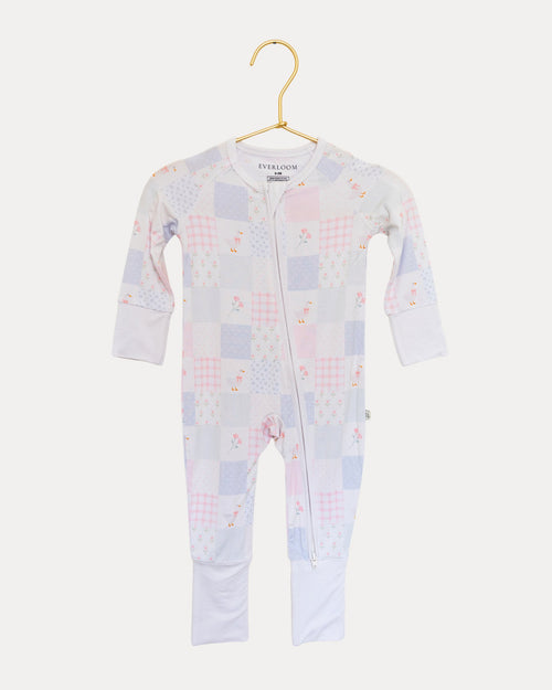 Heirloom Quilt bamboo zip sleeper on a hanger, soft pink and blue patchwork print