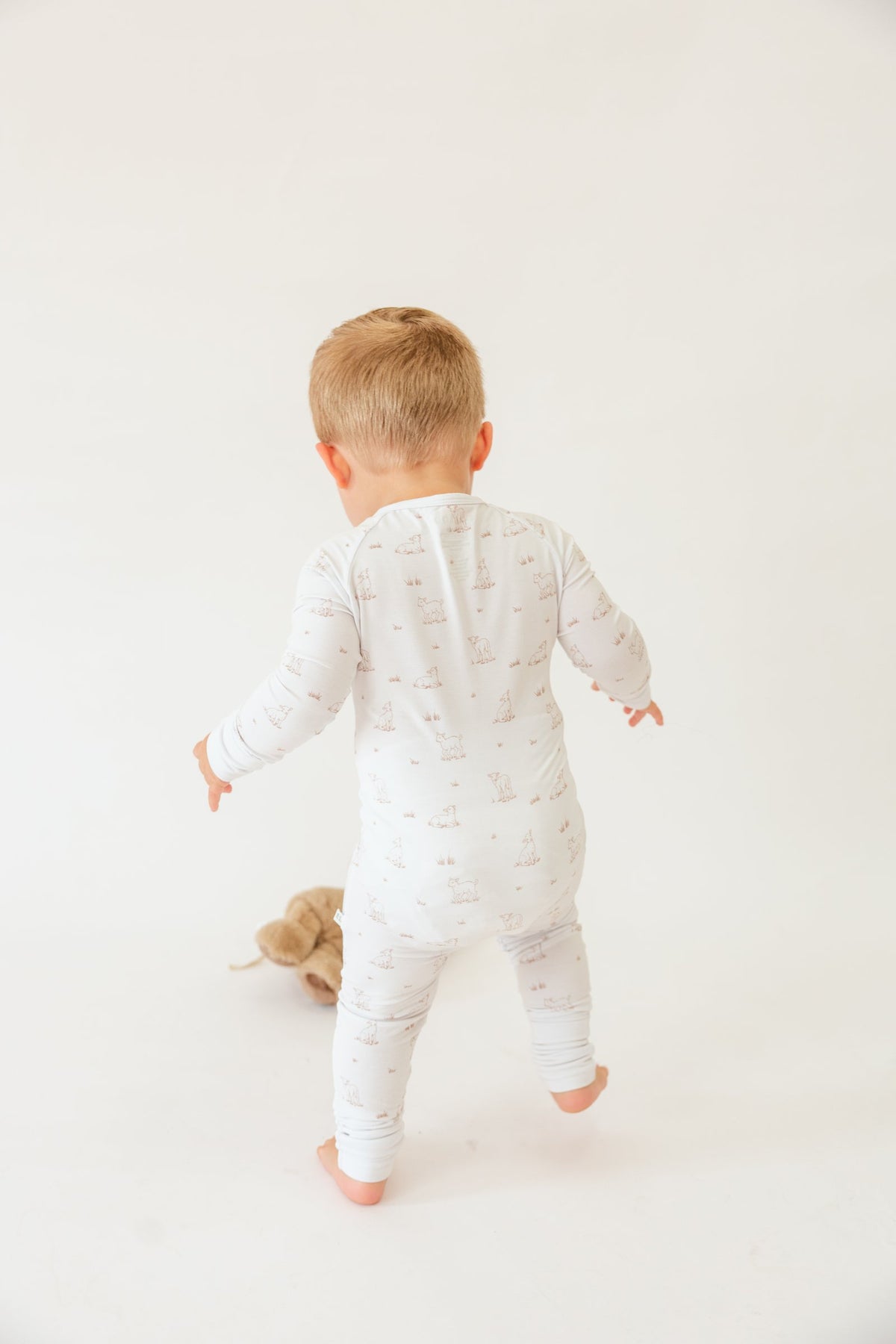 Back view of a toddler walking in the Little Lamb sleeper