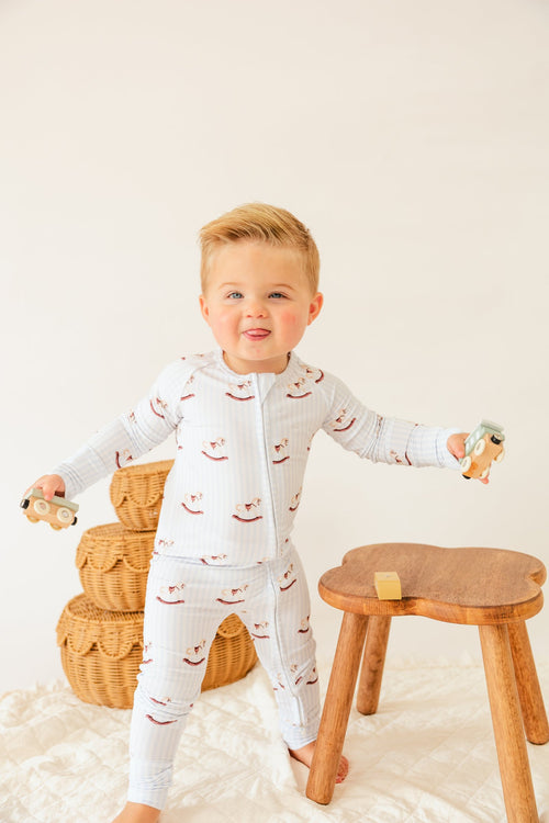 Toddler holding toys in the Rocking Horse bamboo sleeper