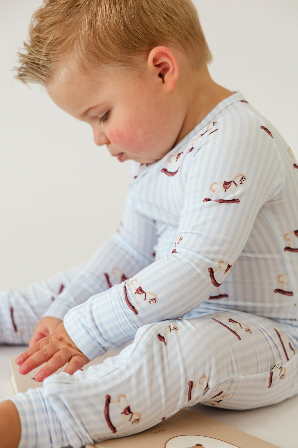 Toddler sitting and playing in the Rocking Horse sleeper